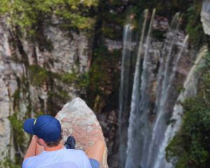 HOMEM SENTADO NO MIRANTE DO CANION DO CACHOEIRÃO